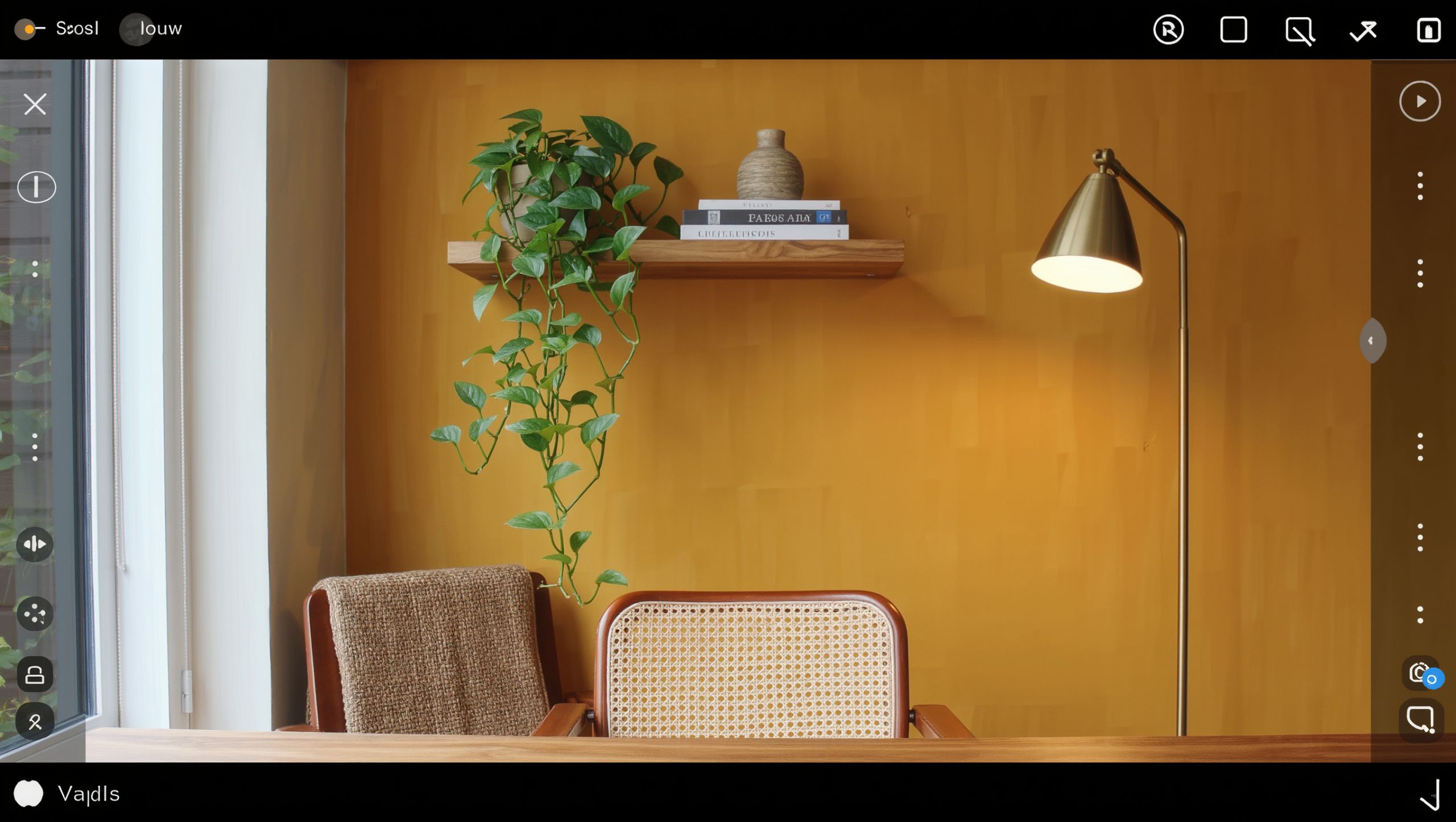 A home office corner with an ochre wall, a floating oak shelf, and a caned lounge chair arranged as a tidy video-call backdrop.