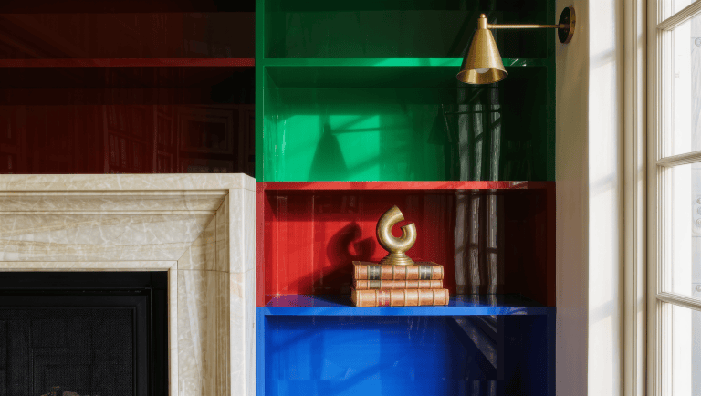A deep architectural alcove built out with jewel-toned lacquered storage shelving