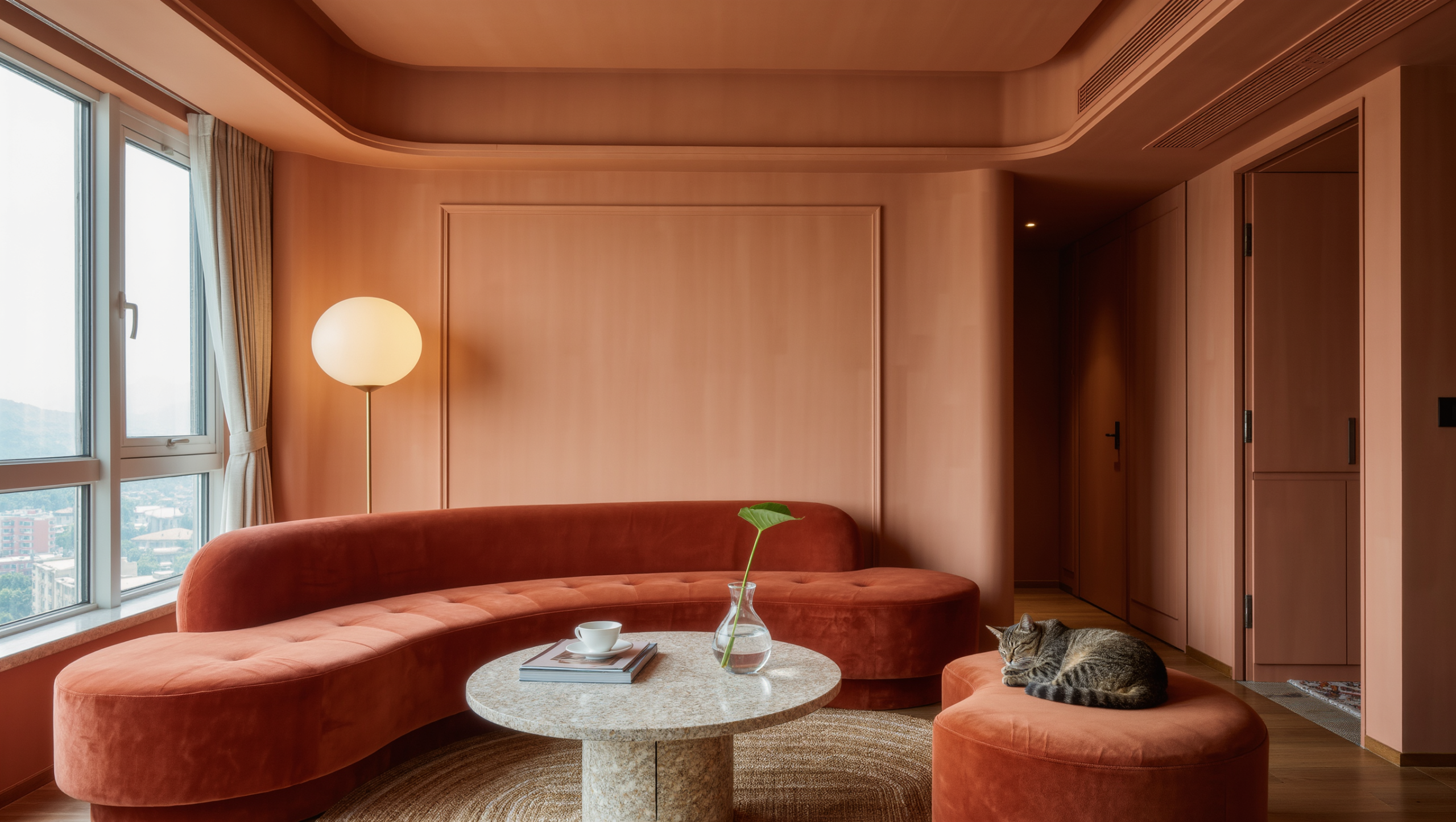 A compact living room with a terracotta curved sofa, round travertine table, and kidney-shaped ottoman easing the walking path.