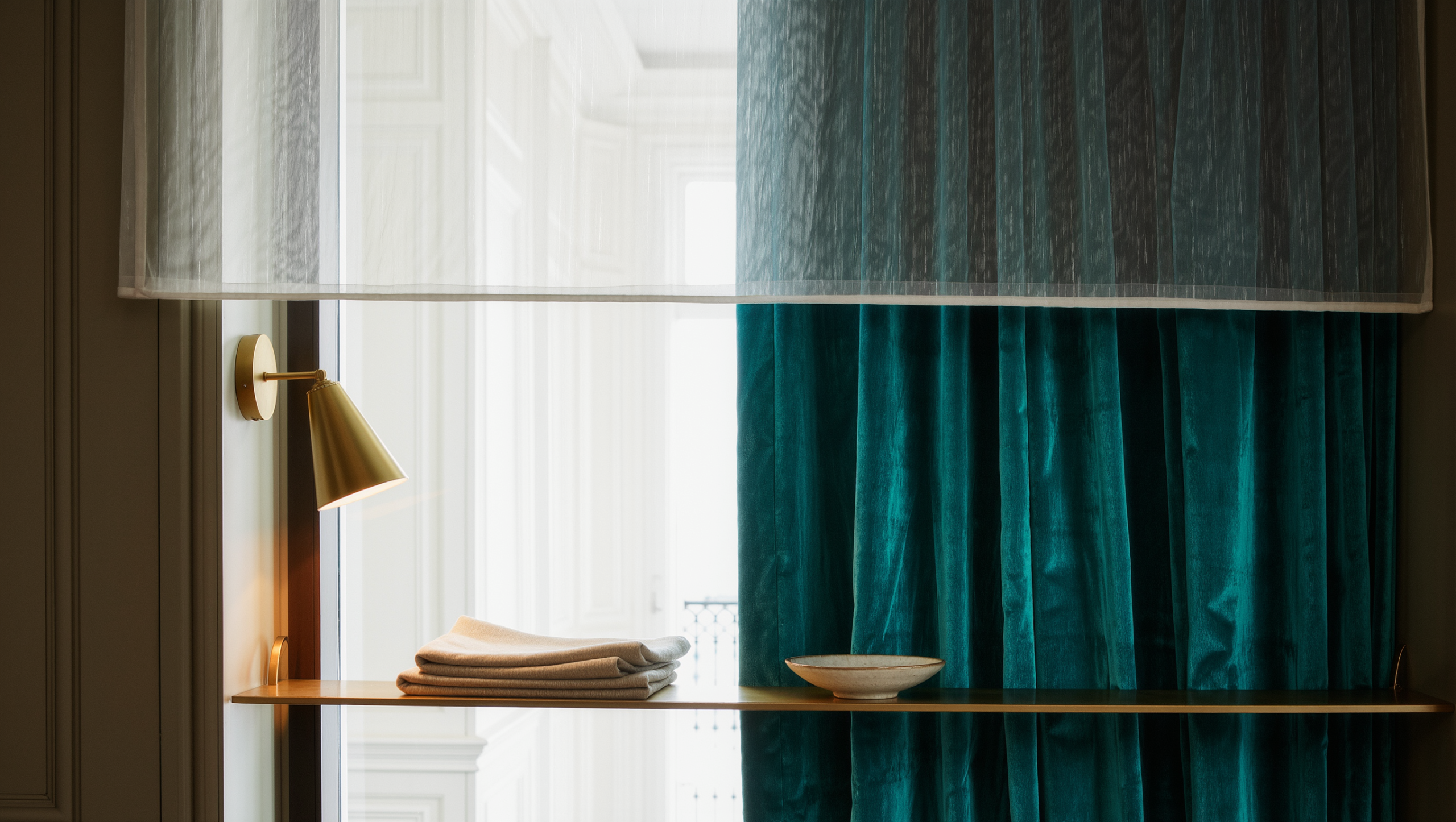 A layered window treatment with a sheer voile panel beneath a heavier velvet curtain