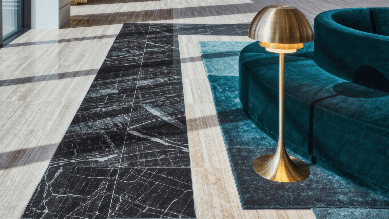 A wide marble border on a large room's floor marking the walking route between a velvet seating zone on a layered rug and open stone floor beyond.