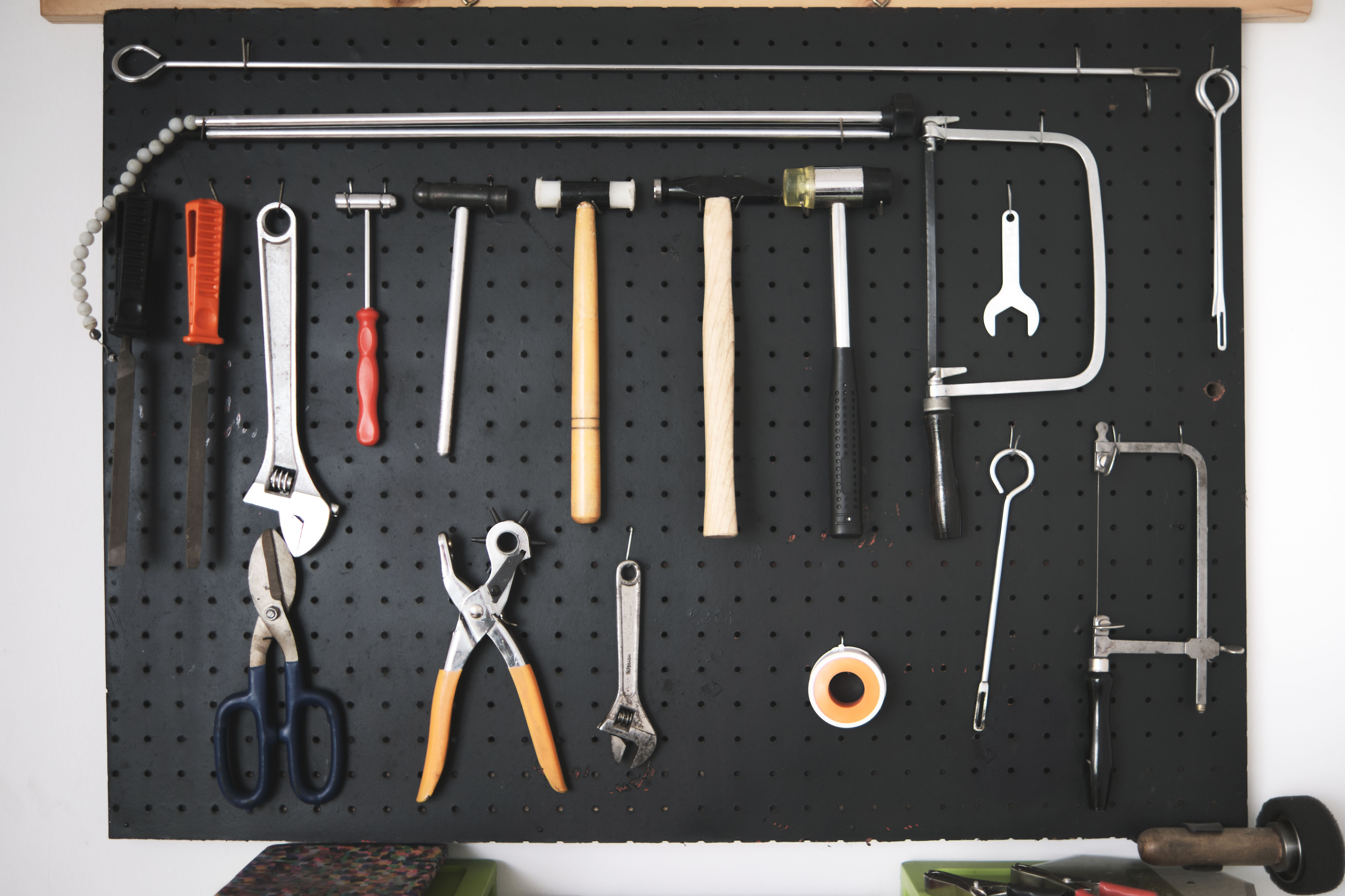 A neatly organized pegboard wall holds hand tools in orderly rows, each hung on its own hook so nothing is stacked or leaning.