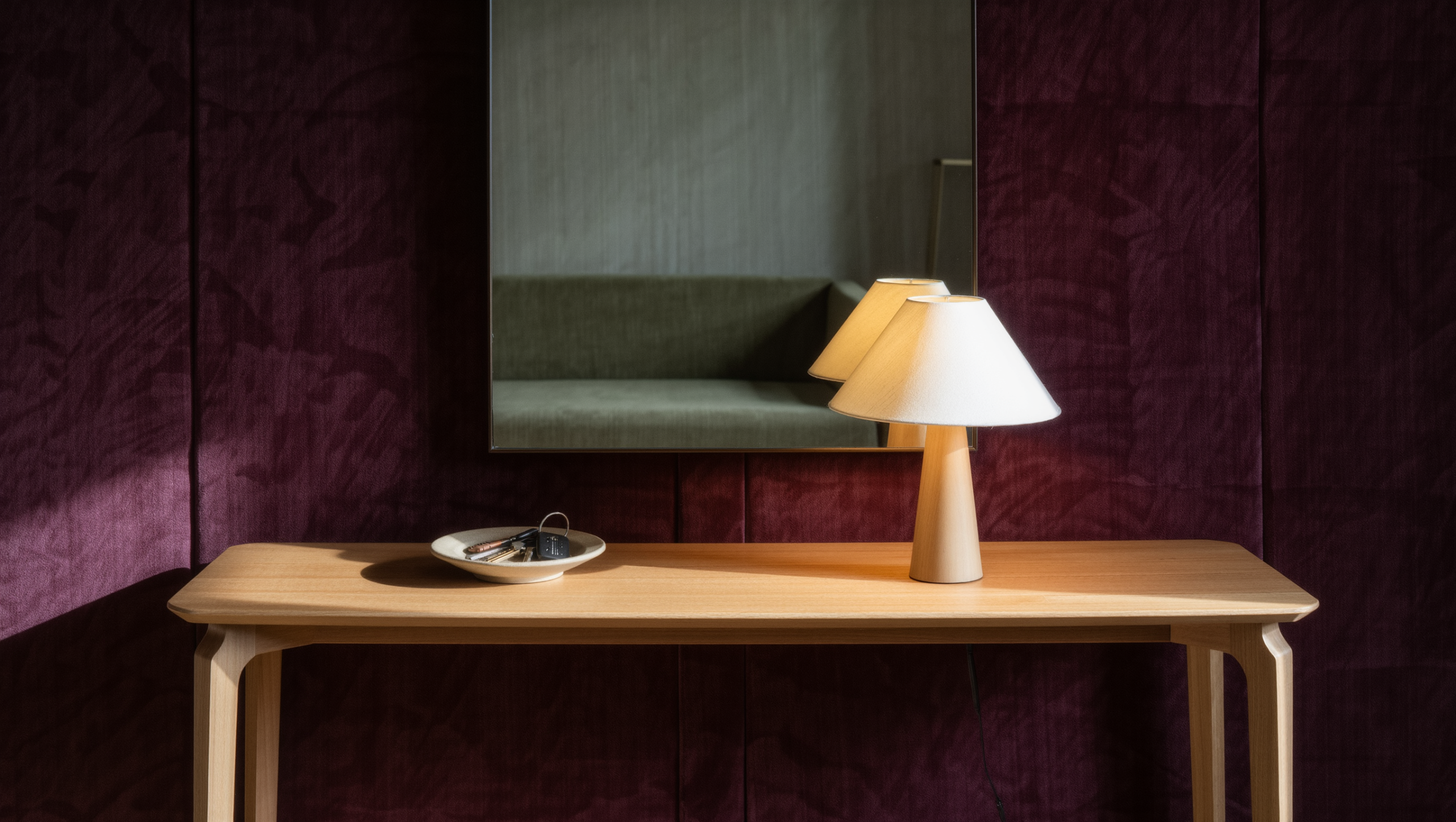 Cleared console table holding only a small tray with keys and one lamp, in soft morning light