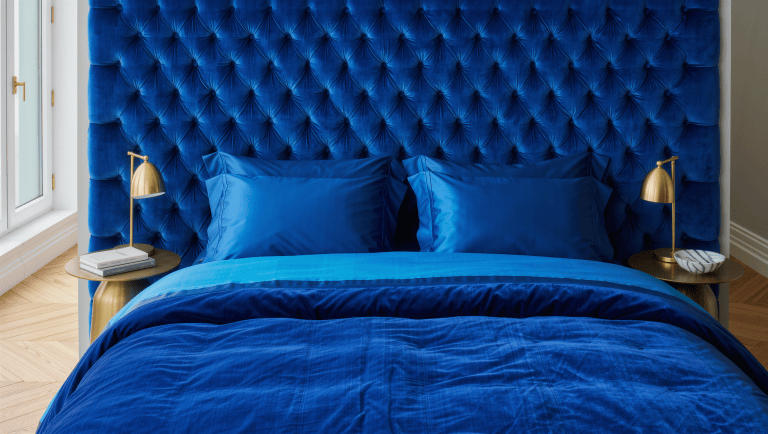 Two matching brass nightstands with lamps flank a jewel-toned headboard, leaving clear floor paths on both sides of the bed.